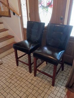 Two brown leather snack bar stools