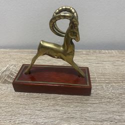 This vintage brass figurine depicts an ibex and is made in the Mid-Century Modern style.