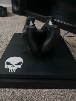 black ps4 and 2 dual shock remotes