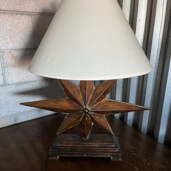 This regent style table lamp features and 8-point star shaped base and contrasting soft back shade.  Product Features : Regent style Materials: Iron, 