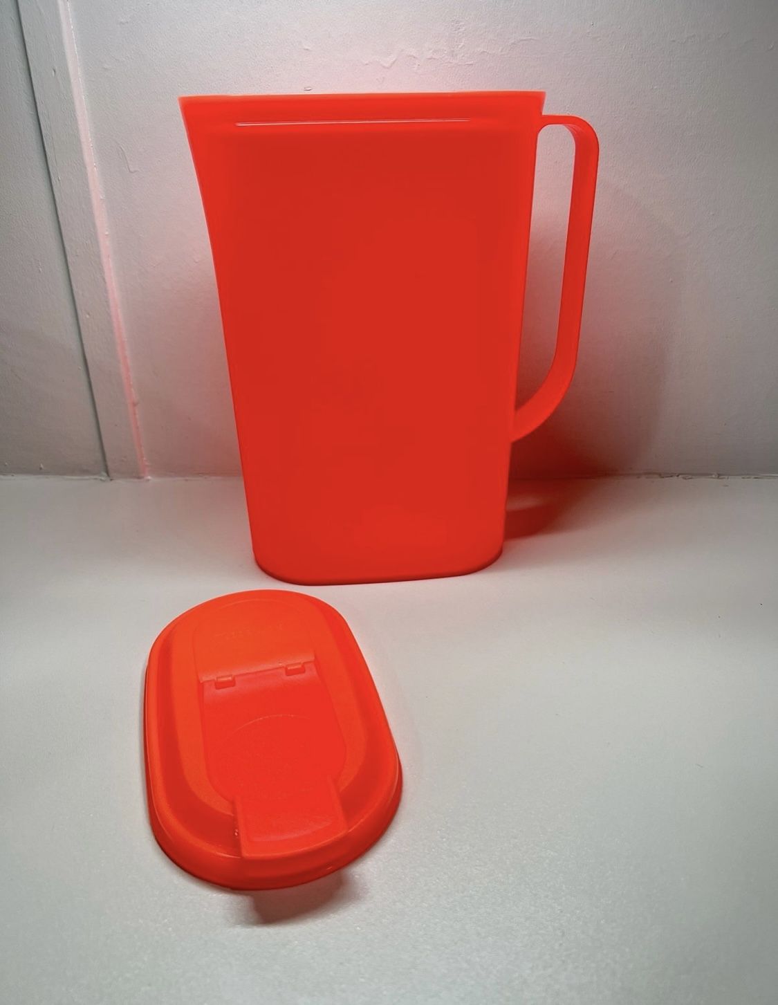 Tupperware pitcher in a reddish orange color