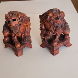 Vintage hand-carved wooden sculptures of pair of Chinese Foo dogs. 
Pre-owned, display item. The carvings are made from natural boxwood and 
feature i