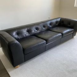 CB2 + GQ "Kotka" black tufted leather sofa