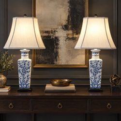 Pair of elegant blue-and-white ceramic table lamps with classic floral design.