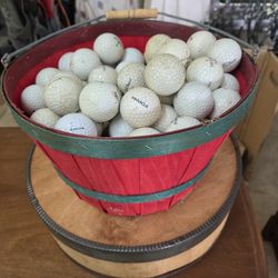 basket full of used  golf balls