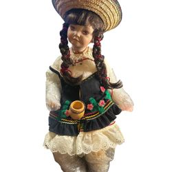 Doll  Madame Alexander doll. Based on its attire, it appears to be a doll from a collection representing different countries, possibly Mexico.  Madame