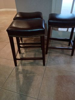 Three brown bar stools