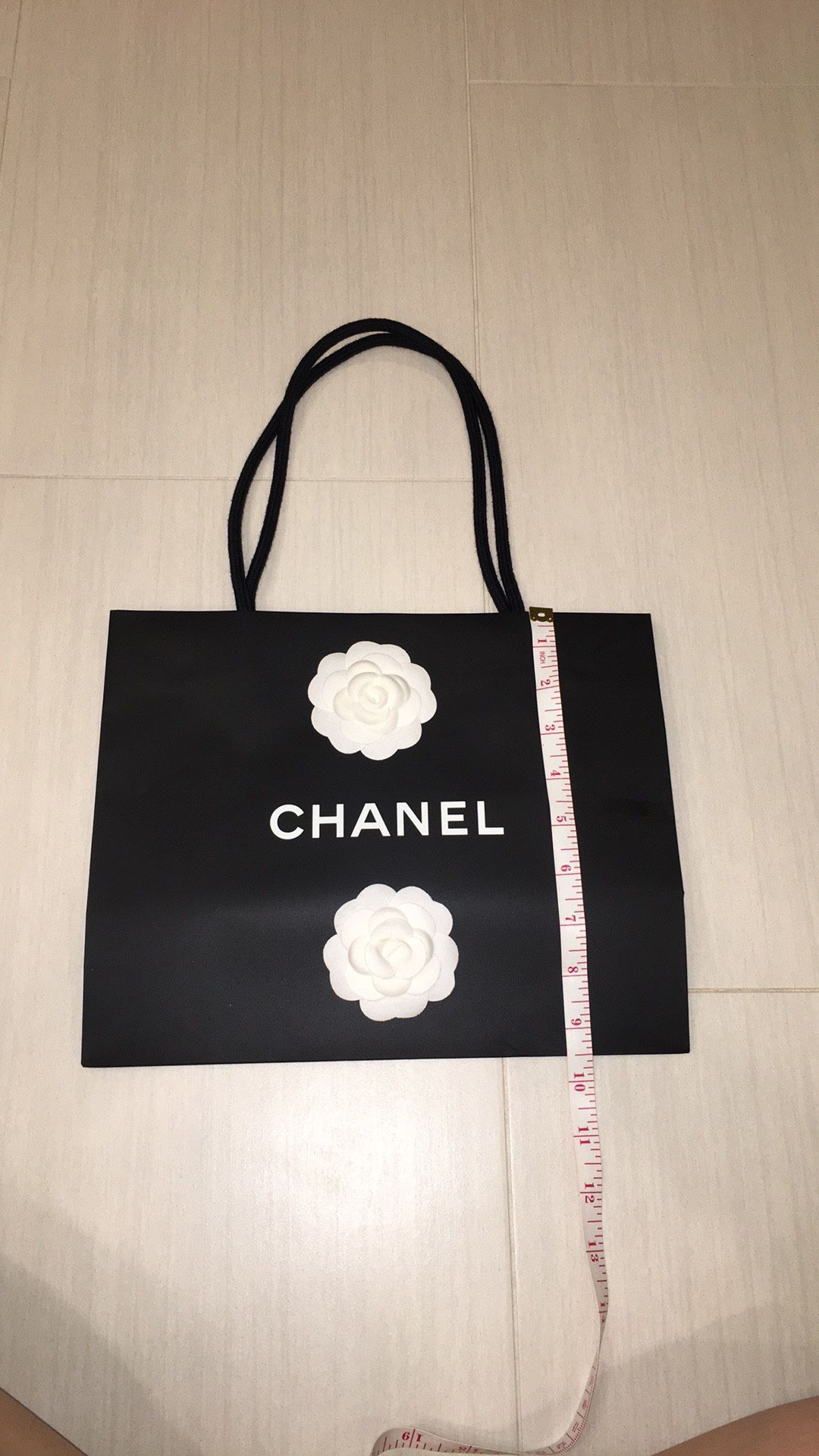 Chanel paper shopping bag with two white flowers and a ribbon