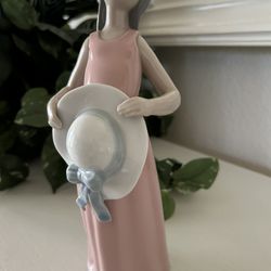 The product is a Lladro "The Dreamer" or "Curious Girl with Straw Hat"