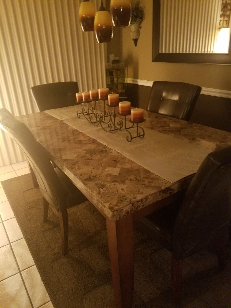marble dining room table with 6 brown leather chairs