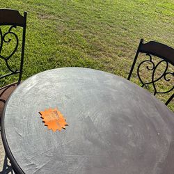 Round dining table with 4 cushion chairs.