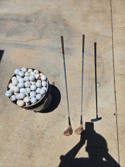 Bucket of golf balls with golf clubs
