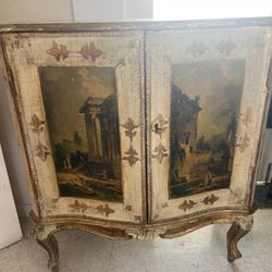 Antique Venetian gold colored cabinet with ornate design and painted panels.