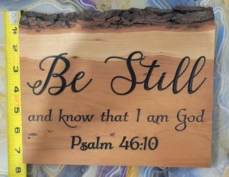 rustic live-edge wood plaque featuring the Bible verse "Be Still and know that I am God. Psalm 46:10" burned or printed in a black script
