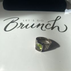 A size 9 cushion-cut peridot signet ring on a silver band. 