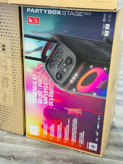 New JBL PartyBox Stage 320 portable speaker. This black unit has a telescopic handle and sturdy wheels for easy transport. It features a futuristic li
