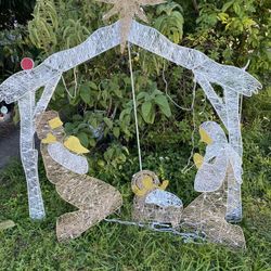 outdoor Christmas Nativity scene featuring the Holy Family under a lighted arch with a star on top