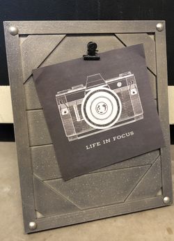 Gray wood memo board sprayed with glitter and furniture pins