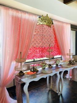 Backdrop de rosas de seda, bases de postres, mesas blancas de madera.