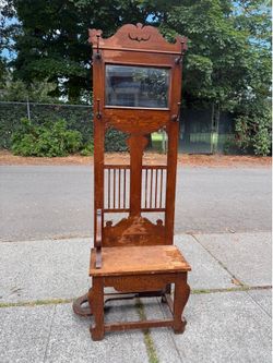 Antique oak hall tree with mirror, coat, hooks, and storage bench
