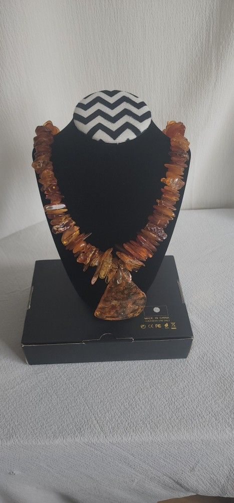 long amber necklace has a medallion