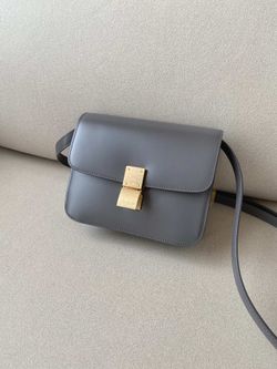 Deep gray, gold-buttoned bag, exuding a vintage, elegant charm.


