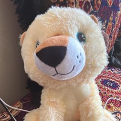 The image shows a plush toy lion, likely a "Your Planet" or "Eco Plush" brand product