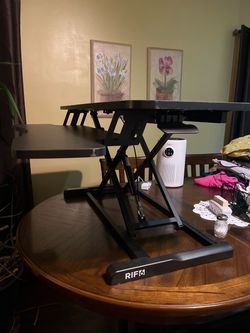 RIF6 standing desk converter in black. Height adjustable unit with a keyboard tray. It's approximately 32" wide by 22" deep (81 cm x 56 cm).