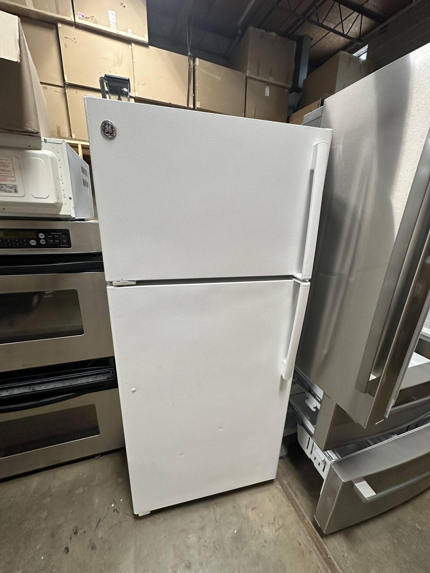 GE brand side-by-side refrigerator with top freezer