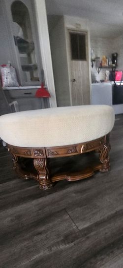 Oval Upholstered Ottoman with Carved Wood Base