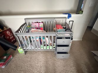 Baby crib with changing station and toys/books