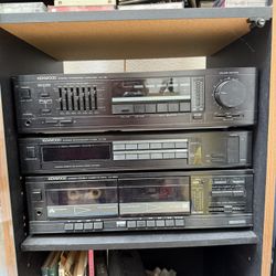 DISCOUNTED Kenwood KA-87, KX-57W, and KT-57 stereo system, which consists of an integrated amplifier, a double cassette deck, and an AM/FM tuner. 