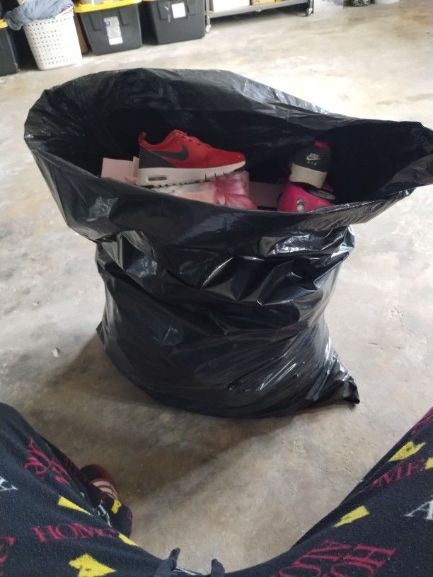 50 Gallon Trash Bag With Numerous Toys And A Pair Of Toddler Nike.