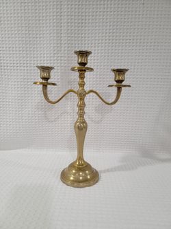 Antique three-armed candelabrum in bronze (or brass), traditional style with a heavy circular base. Classic and ornate design with an aged gold finish