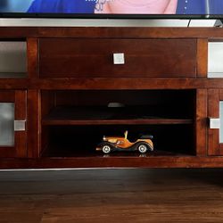 Wooden TV stand dark-stained wood, likely cherry or mahogany veneer