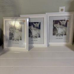 three white picture frames with a mat, designed to hold an 11x14 inch photo. The frames are from the brand Aaron Brothers