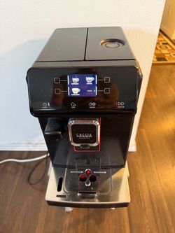 Sophisticated black Gaggia Magenta super-automatic espresso machine. This unit has a digital interface, integrated grinder, and a stainless steel drip