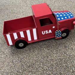 This is a patriotic, rustic metal pickup truck decoration