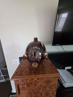 Glossy ceramic piggy bank with a dark brown base and multi-colored drip glaze accents. This piece has a coin slot on the top and a cork stopper in the