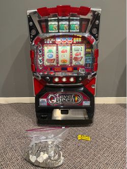 Vintage casino slot machine with 900 tokens and key.