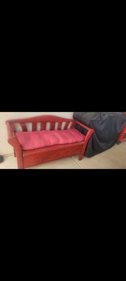 Red wooden bench with storage under the seat