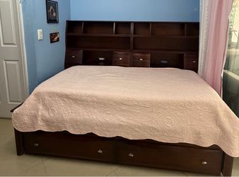 2-in-1 wooden captain's bed (two twin-size beds) with an integrated bookcase; mattresses not included. It is in good condition.