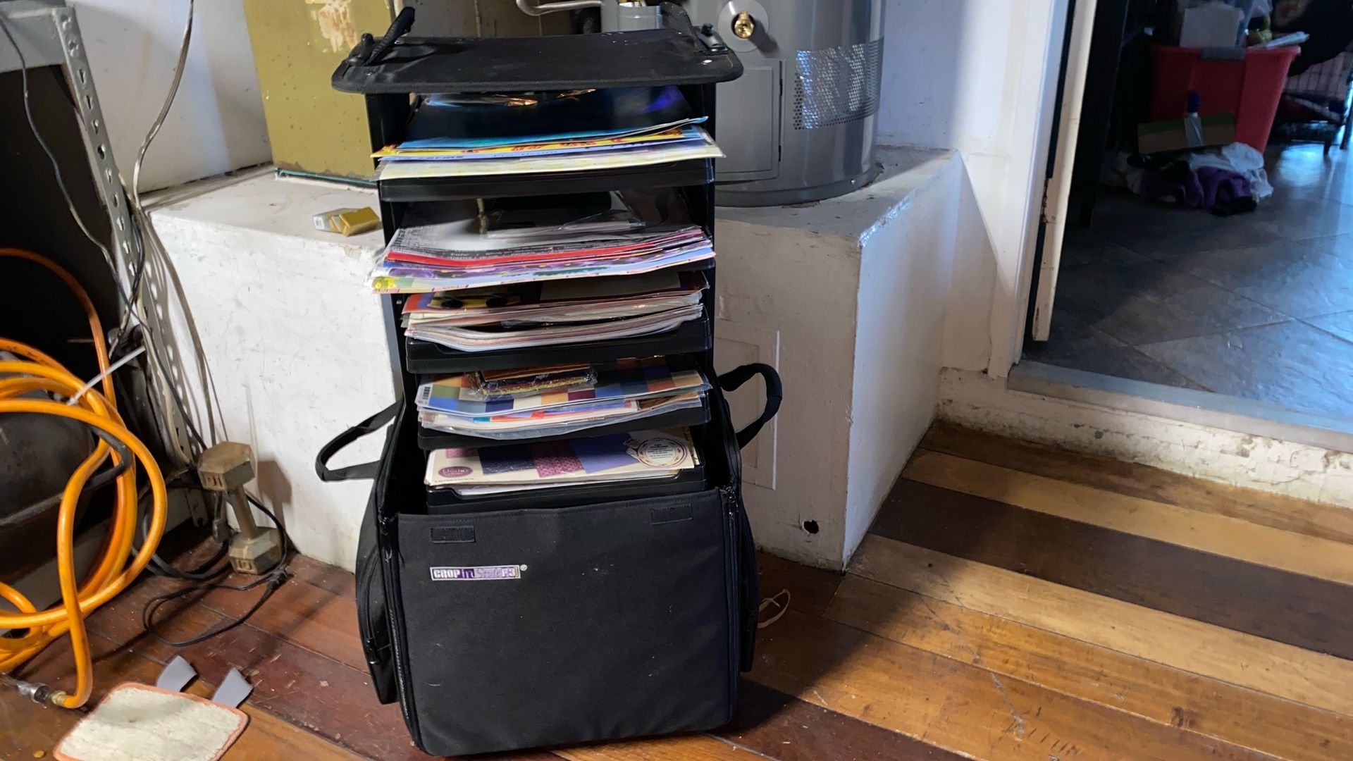 Scrapbooking paper inside a rollaway bag with shelves over 250 pieces of scrap paper also brand new packaged and open Scrap picking materials