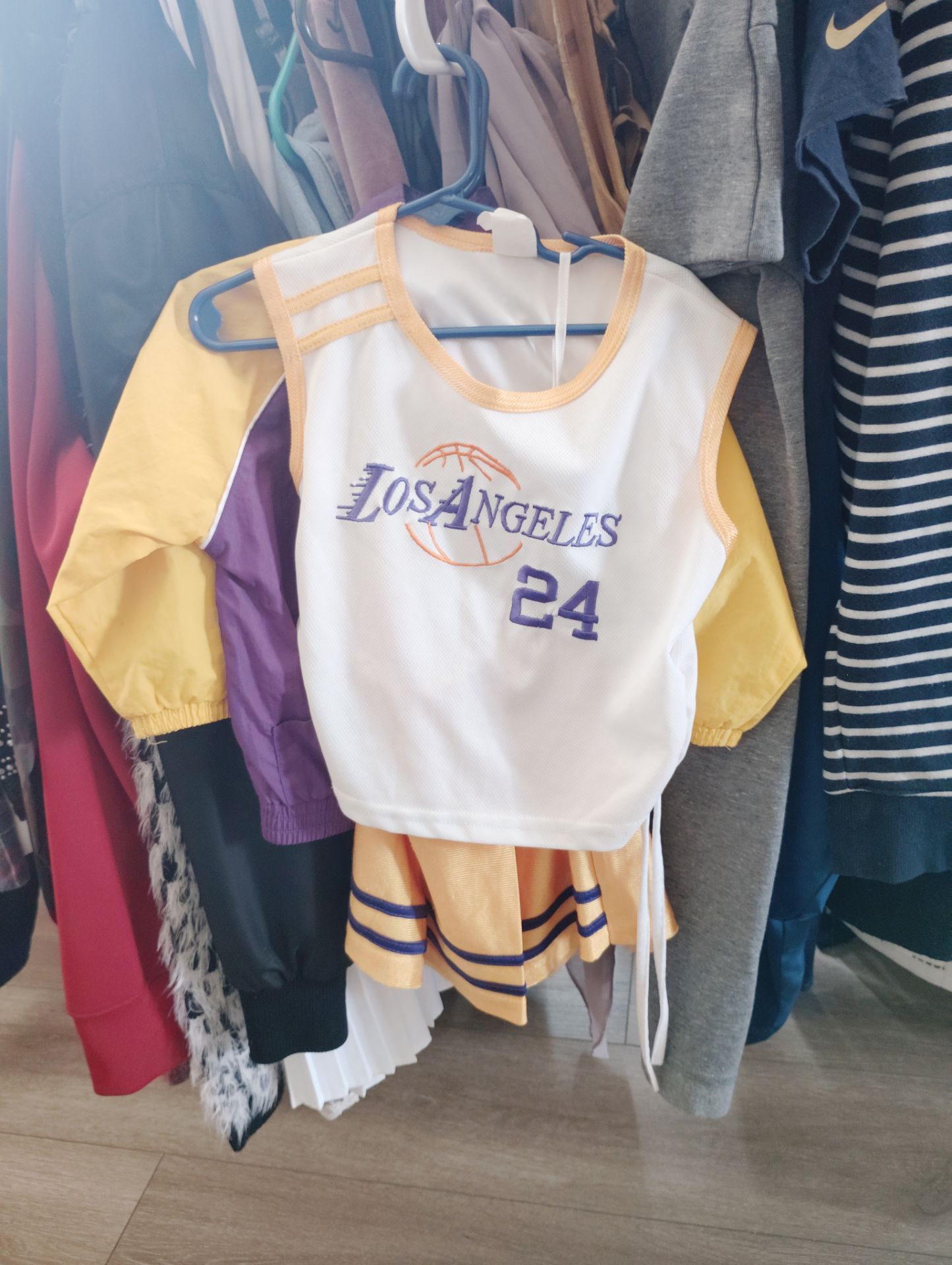 This is a children's Los Angeles Lakers basketball jersey and cheerleader skirt set, styled after player Kobe Bryant's number