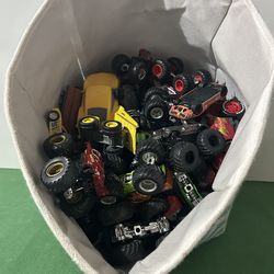 Storage bin, full of toys, monster trucks, cars, and other miscellaneous things