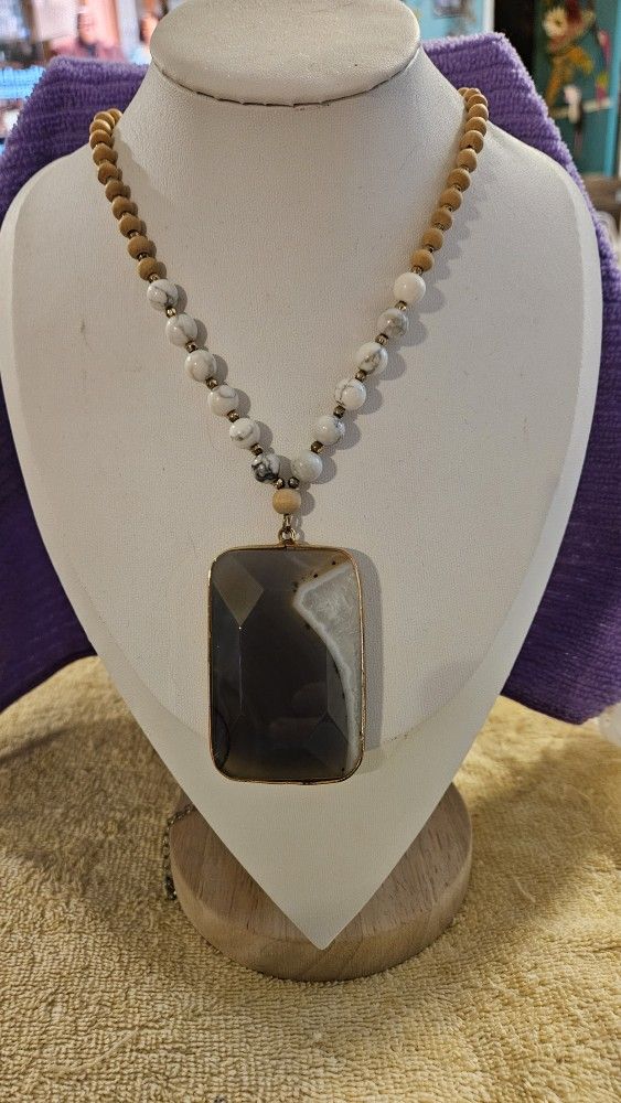 Beautiful Gray and white Agate gold tone framed Necklace with beads of white and vains of gray, and wooden beads, and gold tone spacers, on a gold ton