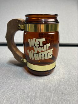 This is a vintage Siesta Ware amber brown glass beer mug with a wooden handle and brass straps.