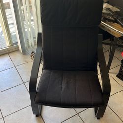 IKEA POÄNG armchair with a black cushion.  