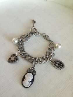 Charm bracelet with cameo, heart, peace sign, love key and white beads