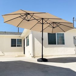 $130 (Brand New) Large 15 ft double sided outdoor umbrella with 65 lbs plastic weight base (beige color) 